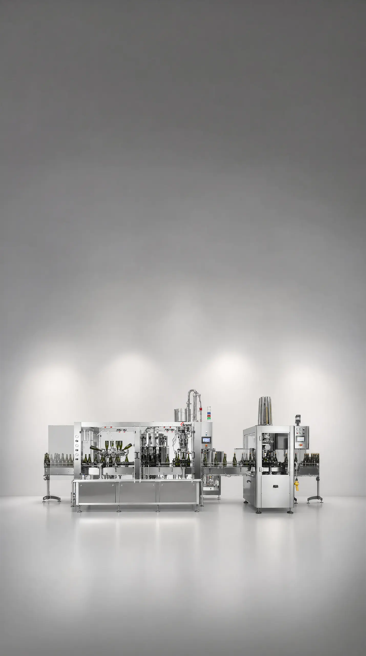 Automated bottling line with glass bottles on a stainless steel conveyor in a bright, minimalist production room.